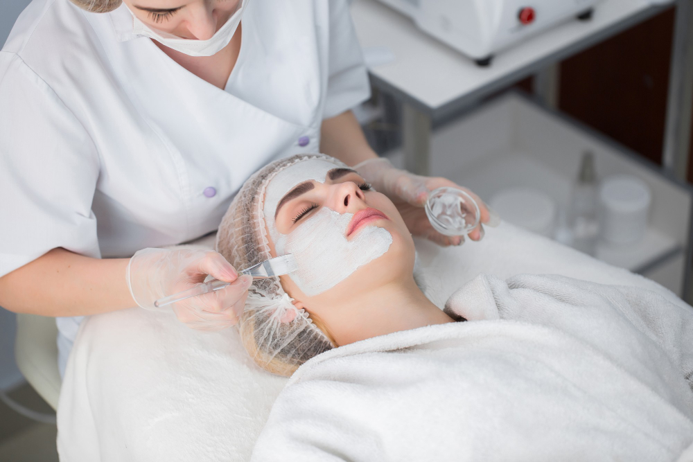 woman getting facial care by beautician spa salon