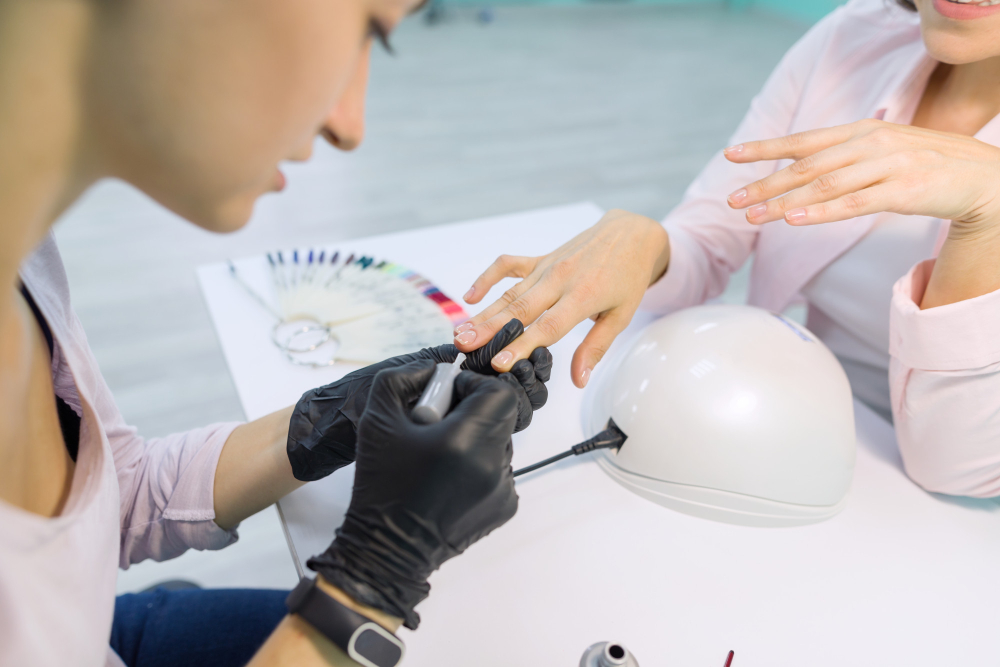 young beautician beauty nail salon doing manicure paints nails